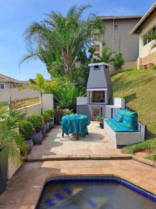 a backyard with a barbecue and a swimming pool at 54 on Asteria 2 in Amanzimtoti
