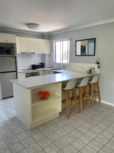 a kitchen with a large island with bar stools at Unit 9 Bellevue in Lakes Entrance