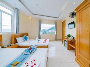 a hotel room with two beds and a window at Lang Chai Hotel - Travel Agency in Cat Ba