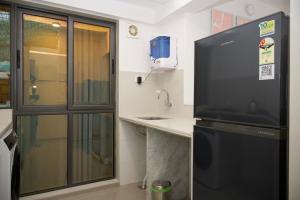a kitchen with a sink and a large television at Z Bliss Suites, BKC in Mumbai