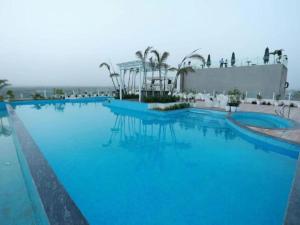 a large swimming pool with blue water at Hotel Diona Palace Jaipur in Jaipur