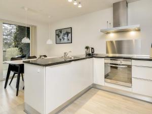 a white kitchen with a sink and a stove at 6 person holiday home in V ggerl se in Marielyst