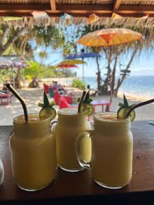 drei Drinks in Mason-Gläsern auf einem Tisch nahe dem Strand in der Unterkunft The Kori Sire in Tanjung