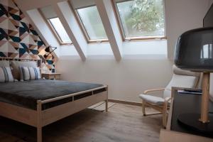 um quarto com uma cama, uma cadeira e janelas em high-Q em Kowalewo