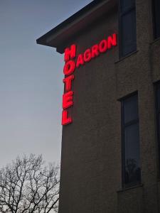 ein Neonschild an der Seite eines Gebäudes in der Unterkunft Hotel Agron in Tirana