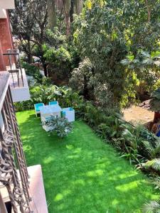 un jardín con bancos azules en la hierba en 108 LazyStays - 2 BHK brand new flat in Arpora, en Arpora
