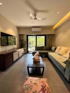 a living room with a couch and a table at 108 LazyStays - 2 BHK brand new flat in Arpora in Arpora