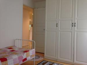 a bedroom with a bed and a closet with white cabinets at 2 Bedrooms apartment in a villa, close to nature. in Västerås