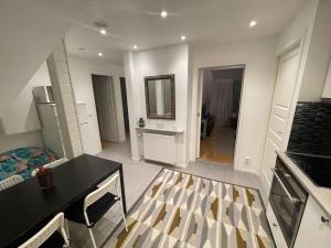 a living room with a table and a kitchen at 2 Bedrooms apartment in a villa, close to nature. in Västerås
