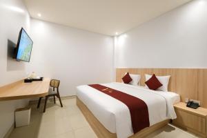 una camera d'albergo con letto e scrivania di ValStar Hotel Canggu a Canggu