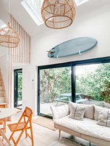 ein Wohnzimmer mit einem Sofa und einem Surfbrett an der Wand in der Unterkunft Lowen Tree House in Truro