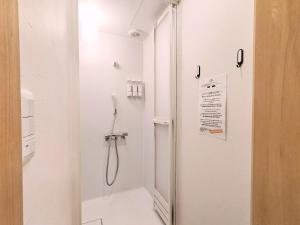 a white bathroom with a shower and a toilet at Sho inn MINIMAL HOTEL 小樽駅から無料送迎あり in Otaru