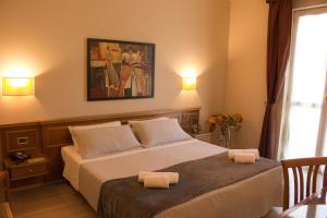 a bedroom with a bed with two towels on it at Hotel Valentino in Acqui Terme