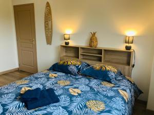 1 dormitorio con 1 cama con edredón azul y amarillo en Au pied des batteries, en Longues-sur-Mer