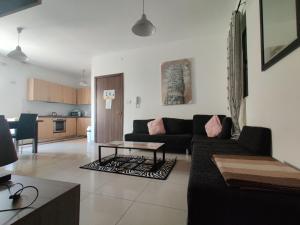 a living room with a couch and a table at St Julians Sliema 3 minutes walk from promenade 3 bedroom apartment in Sliema