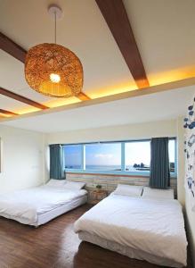 Un dormitorio con dos camas y una gran ventana. en sea monkey diving homestay, en Isla Verde