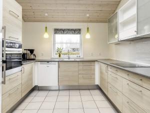 a kitchen with white cabinets and a window at 8 person holiday home in V ggerl se in Marielyst