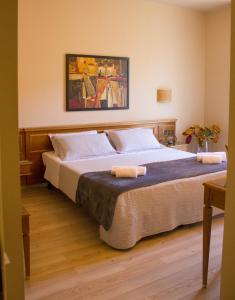 a bedroom with a large bed with two towels on it at Hotel Valentino in Acqui Terme