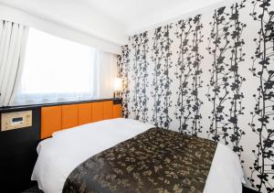 a bedroom with a bed with a black and white patterned wall at APA Hotel Fukuoka Tenjin Nishi in Fukuoka