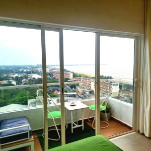 a bedroom with a balcony with a table and chairs at Ocean Breeze Residence- Negombo in Negombo
