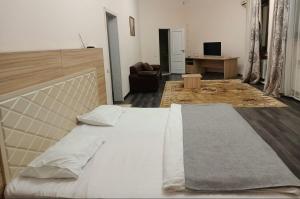 ein Schlafzimmer mit einem großen Bett und ein Wohnzimmer in der Unterkunft Merdan Hotel in Zaozërnyy