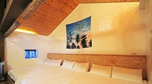 Una cama en un dormitorio con un cuadro en la pared. en sea monkey diving homestay, en Isla Verde