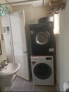 ein Badezimmer mit einer Waschmaschine und einem Waschbecken in der Unterkunft 2BR avida tower near NAIA airport in Manila