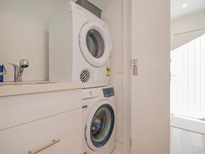 uma máquina de lavar e secar roupa numa lavandaria branca em Tairua Marina Villa em Tairua