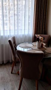 een tafel en stoelen in een kamer met een raam bij Apartment next to Cathedral of Saints Peter & Paul in Šiauliai