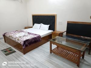 a small bedroom with a bed and a table at Tarangamala Resort in Mandarmoni