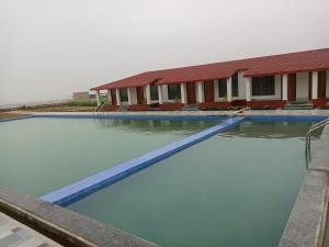 a large pool of water in front of a building at Tarangamala Resort in Mandarmoni