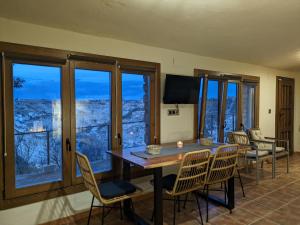 a dining room with a table and chairs and windows at Casa Rural Alikakaro in Alcalá del Júcar +17 photos
