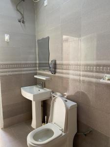 uma casa de banho com um WC e um lavatório em FIG SHADES مزرعة ظلال التين em Ţīwī