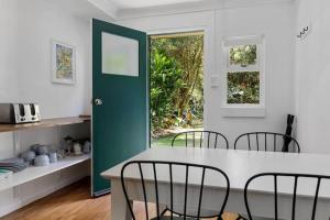 a kitchen with a table and chairs and a green door at Rosella's On Springbrook in Springbrook