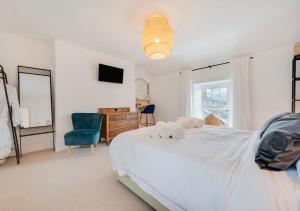a bedroom with a white bed and a blue chair at Rhyd y Fen in Aberaeron