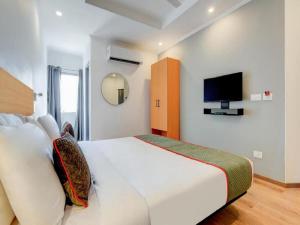 um quarto com uma cama branca e uma televisão em HOTEL CHETRAM ELITE near railway station em Jaipur