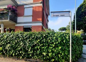 ein Straßenschild vor einem Busch neben einem Gebäude in der Unterkunft La Casetta di Maria in Lido di Venezia