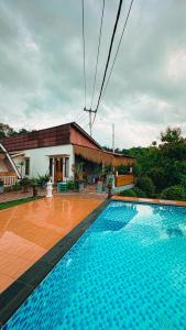 a large swimming pool in front of a house at Penida Hills Hostel in Nusa Penida