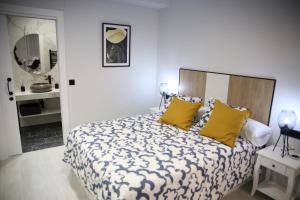 a bedroom with a large bed with yellow pillows at E&R-1 Plaza España in Salamanca
