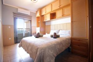 Un dormitorio con una cama grande con armarios de madera. en See view, relaxed, en Torrevieja