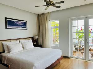 - une chambre avec un lit et un ventilateur de plafond dans l'établissement Di Lusso Boutique Riverside Danang Hotel, à Đà Nẵng