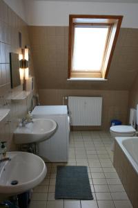 a bathroom with two sinks and a toilet and a window at "Alte Sparkasse" Nr1 in Landkirchen
