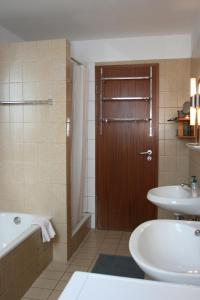 ein Badezimmer mit einer Badewanne, einem WC und einem Waschbecken in der Unterkunft "Alte Sparkasse" Nr1 in Landkirchen