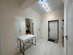 Habitación blanca con tocador y espejo. en 2-комнатные апартаменты в новом жилом комплексе, en Almaty