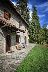 ein Haus mit einem Stuhl und einem Tisch davor in der Unterkunft Casale La Fabbrica in San Romano