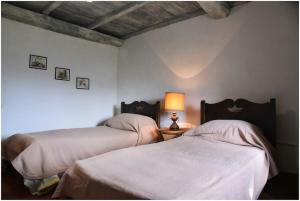 ein Schlafzimmer mit 2 Betten und einer Lampe auf einem Tisch in der Unterkunft Casale La Fabbrica in San Romano