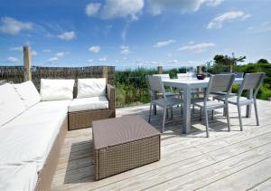 a patio with a couch and a table and chairs at Morannedd in Abersoch