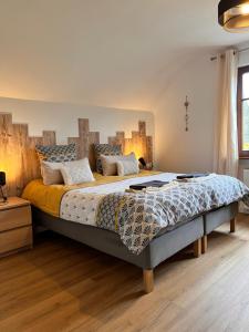 una camera con un grande letto con testiera in legno di Maison d'hôtes en forêt avec des chevaux, Domaine du Trèfle d'Or a Soucht