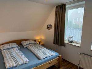Bett in einem Zimmer mit Fenster in der Unterkunft "Alte Sparkasse" Nr1 in Landkirchen