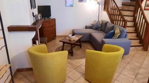 ein Wohnzimmer mit Sofa, Stühlen und einem Tisch in der Unterkunft A 200 mètres du château : maison de ville in Carcassonne + 14 Fotos